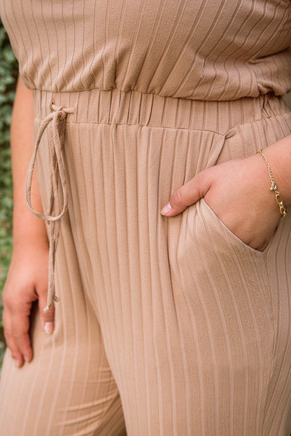 Flat lay of Cruiser Jumpsuit in Tan, front view, available at J&J Shop Online.