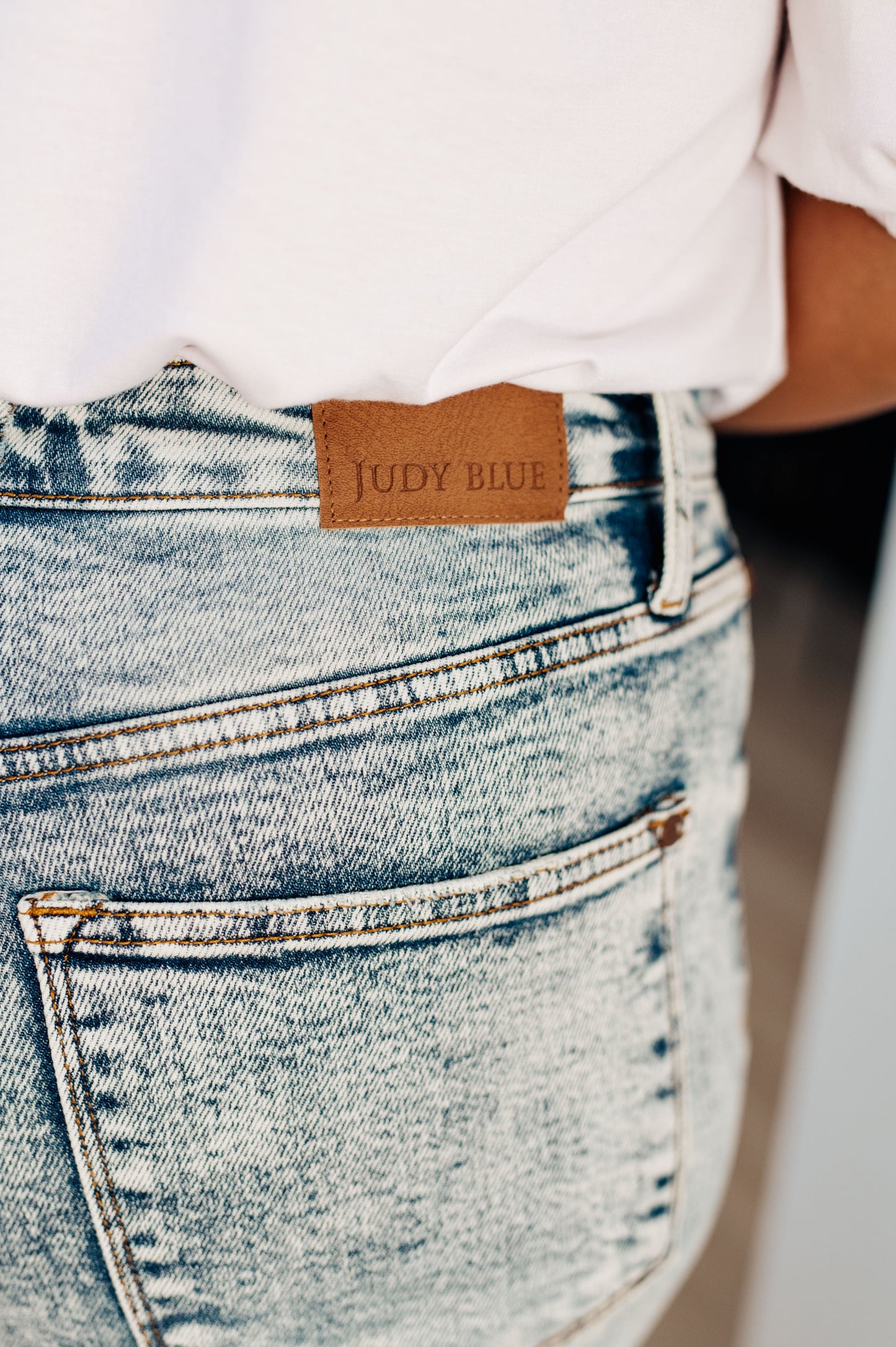 Close-up of the high-rise waist on the Dory High Waist Mineral Wash Raw Hem Wide Leg Jeans by Judy Blue, available at J&J, as seen on Jessica and Juan from 90 Day Fiancé.