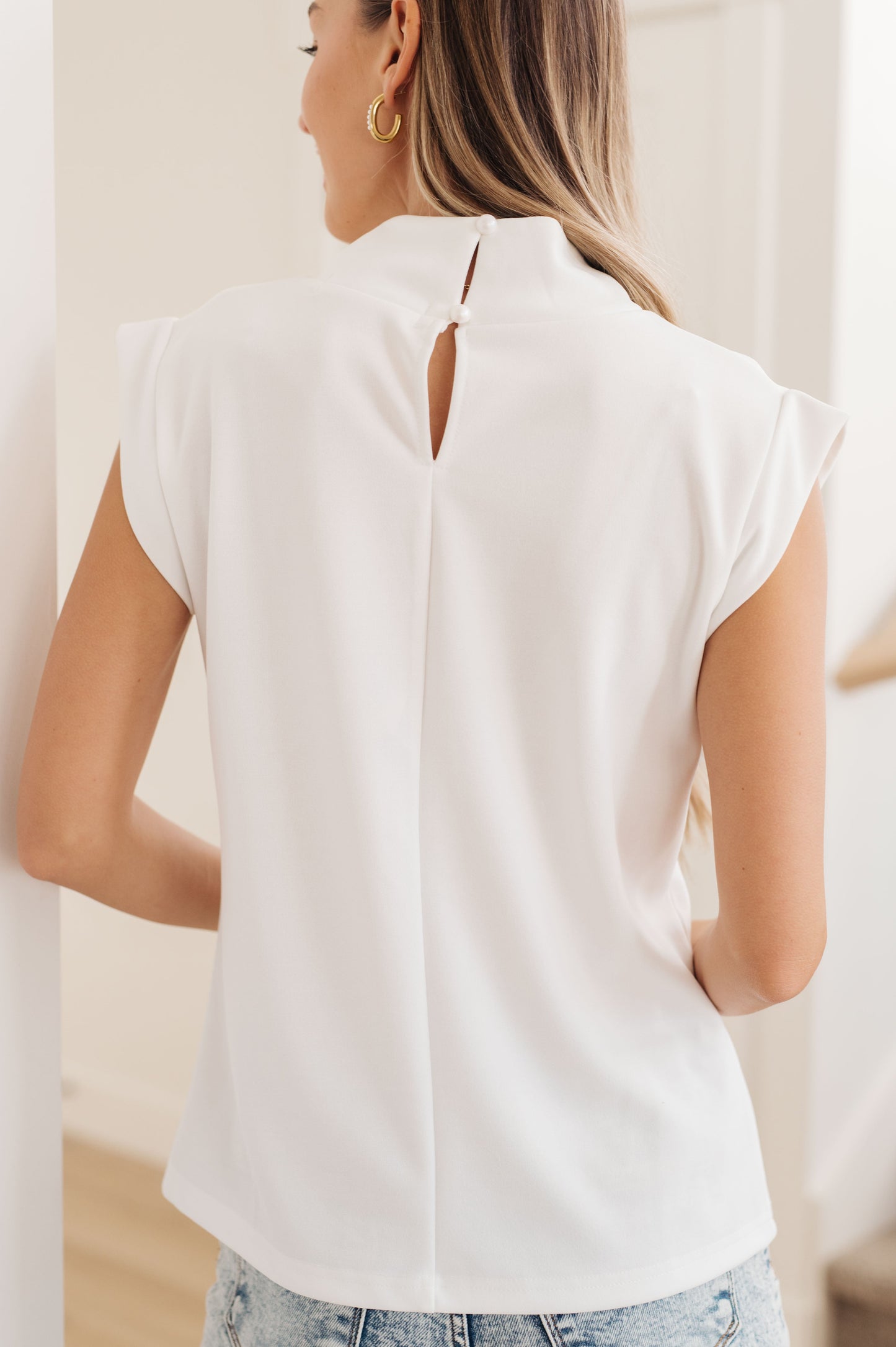 Detailed back design of the Overqualified Mock Neck Cap Sleeve Top, showcasing its elegant fit and banded cap sleeves.